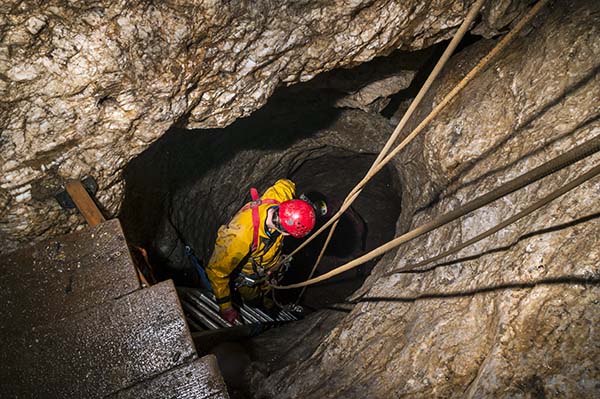Caver on ladder in a dig
